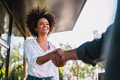 Businessman and woman shake hands like hello in office closeup.