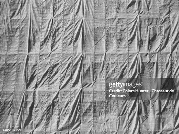 a tarpaulin in white and opaque fabrics covers a scaffolding in paris, france - tarpaulin stock pictures, royalty-free photos & images