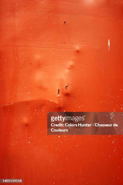 dented metal plate, painted orange with some rust and splashes of white paint in paris - abollado fotografías e imágenes de stock