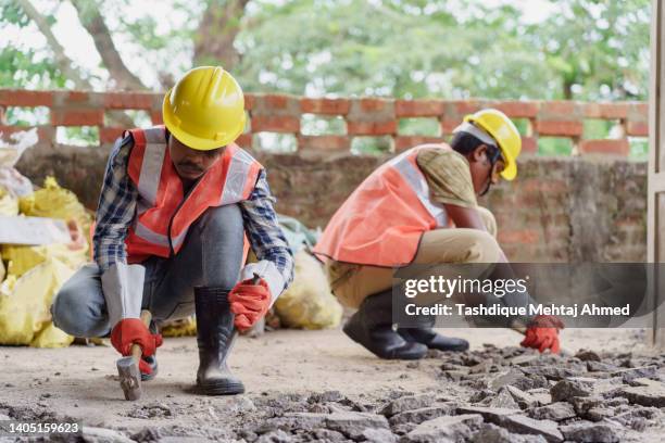 construction workers engaged in building construction. - indian construction worker stock pictures, royalty-free photos & images
