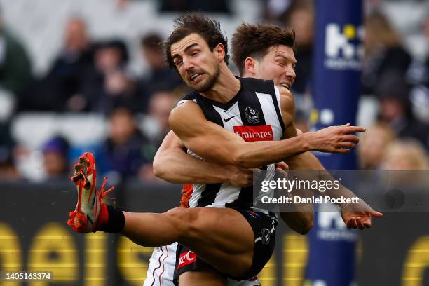 Josh Daicos of the Magpies kicks the ball whilst being tackled by Toby Greene of the Giants during the round 15 AFL match between the Collingwood...