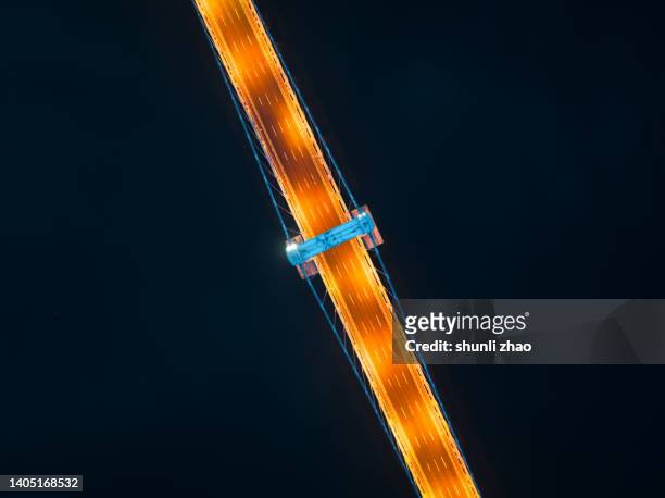 aerial view of cross-sea bridge at night - stahlkabel stock-fotos und bilder