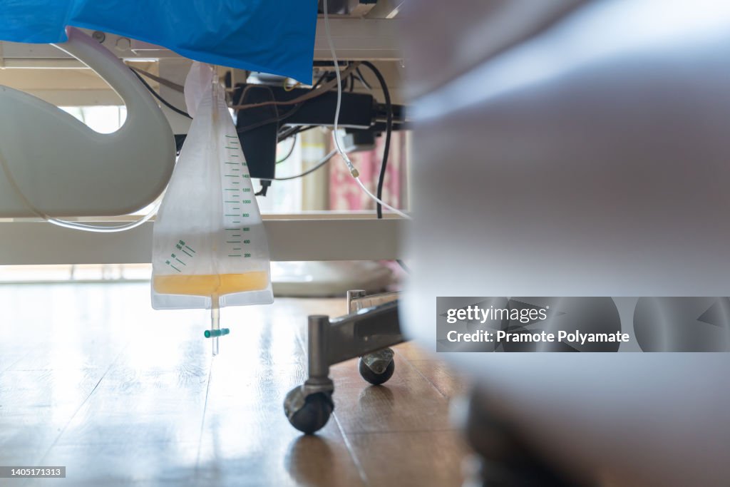 Urine or pee catheter bag hang under patient bed in hospital. Medical Concept.
