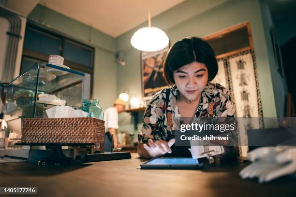 asian women owner checking on financial bill when restaurant closed. - closing laptop stock pictures, royalty-free photos & images