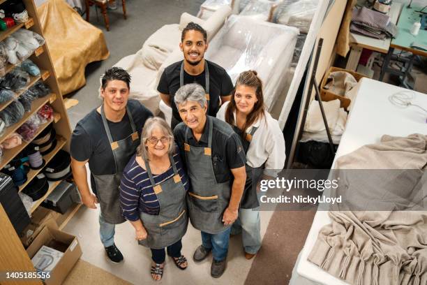 propietario sonriente y personal de pie en un taller de fabricación de muebles - upholstered furniture fotografías e imágenes de stock