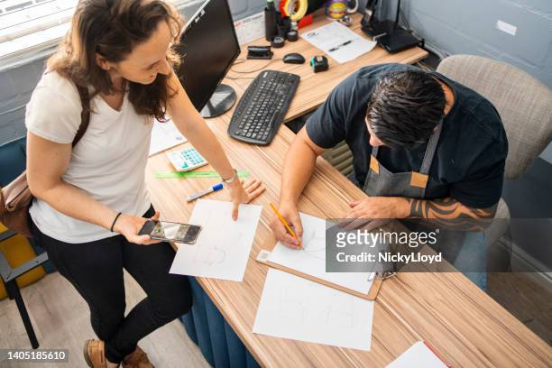 designer and a customer discussing furniture design ideas at a workshop desk - upholstered furniture stock pictures, royalty-free photos & images