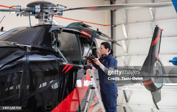 ingénieure aero en travaillant sur l’hélicoptère dans le hangar - helicopter photos et images de collection