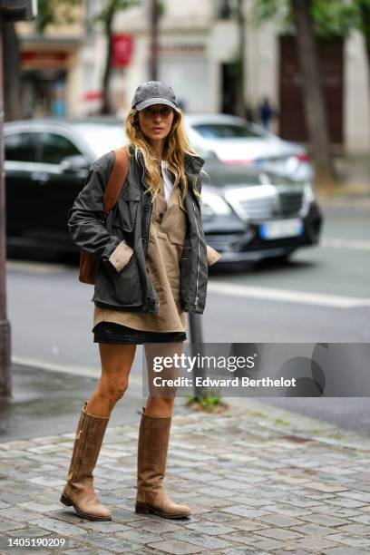 Guest wears a gray denim cap, a gray cargo jacket, a white t-shirt, a beige V-neck denim oversized jacket, a black short skirt, a brown shiny leather...