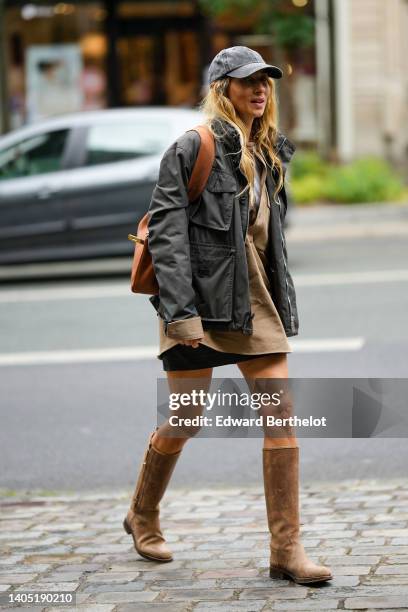 Guest wears a gray denim cap, a gray cargo jacket, a white t-shirt, a beige V-neck denim oversized jacket, a black short skirt, a brown shiny leather...