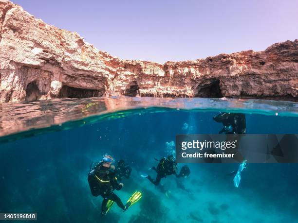 scuba divers exploring and enjoying sea life - cliff dive stock pictures, royalty-free photos & images