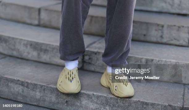 Guest seen wearing a dark grey jogger pants from Urban Outfitters, white socks and beige Adidas Yeezy Foam shoes, outside the Nahmias show, during...