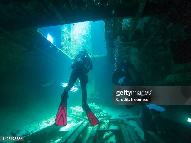scuba divers inside a shipwreck - shipwreck stock pictures, royalty-free photos & images