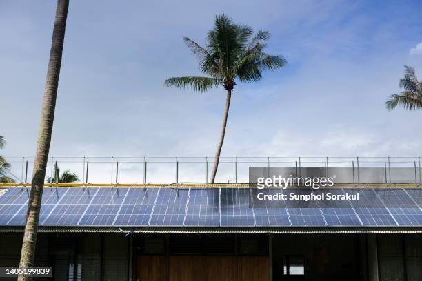 a tropical long house cottage roof with rows of photovoltaic solar cells covering, krabi thailand - zonne eiland stockfoto's en -beelden