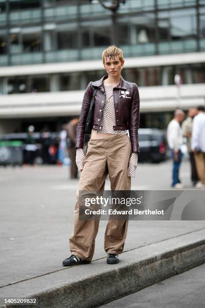 Model wears a brown and white latte checkered print pattern long sleeves / buttoned / slit t-shirt, a brown varnished shiny leather cropped jacket...