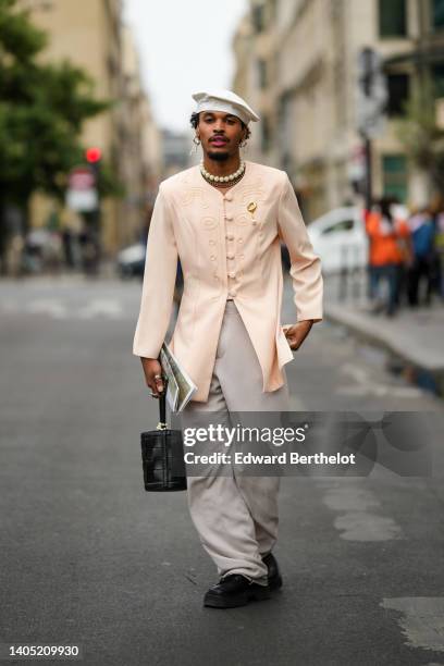 Guest wears a white beret, gold earrings, a beige embossed pattern / buttoned jacket, gray large pants, a black shiny leather crocodile print pattern...