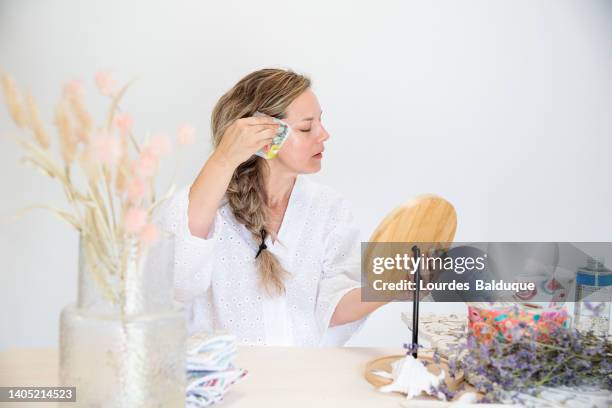 woman using ecological facial hygiene towel in front of the mirror - cotton pad stock pictures, royalty-free photos & images