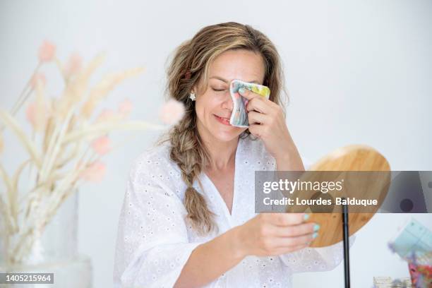 woman using ecological facial hygiene towel in front of the mirror - waschlappen stock-fotos und bilder