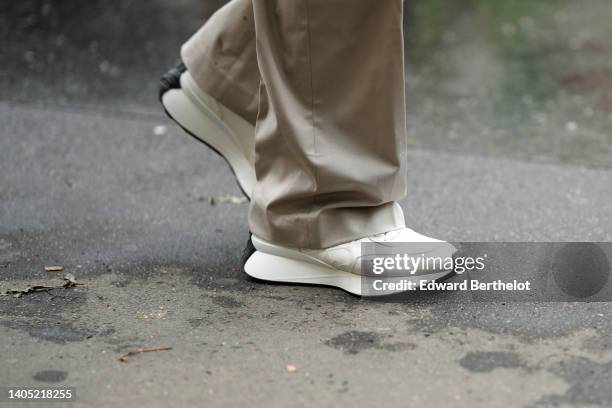 Guest wears beige suit pants, beige matte leather sneakers from Loewe, outside the Hermes show, during Paris Fashion Week - Menswear Spring/Summer...