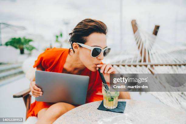 woman at beach cafe drinking mojito - itinerant stock pictures, royalty-free photos & images