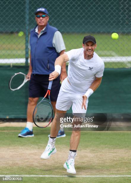 Andy Murray of Great Britian serves as their coach Ivan Lendl looks on during a practice session ahead of The Championships Wimbledon 2022 at All...