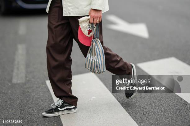 Guest wears a white latte shiny leather long shirt, a dark brown shiny leather crocodile print pattern necklace bag, dark brown suit pants, a beige...