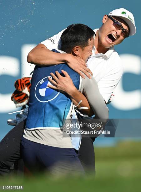 Haotong Li of China celebrates with their caddie on the 18th hole following the playoff during Day Four of the BMW International Open at Golfclub...
