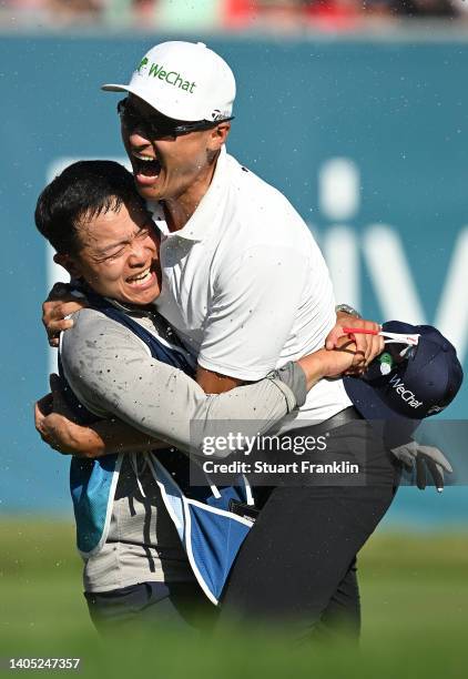 Haotong Li of China celebrates with their caddie on the 18th hole following the playoff during Day Four of the BMW International Open at Golfclub...