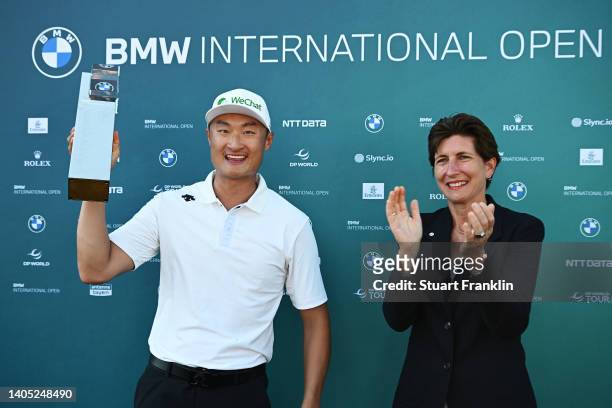 Haotong Li of China celebrates with the winner's trophy alongside Ilka Horstmeier, Member of the Board of Management of BMW AG during Day Four of the...