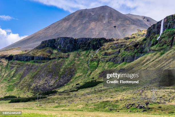 cliffs with the bjarnarfoss waterfall in the front and maelifell mountain in the background - maelifell stock pictures, royalty-free photos & images