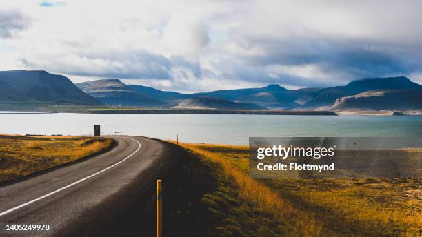 panoramic view of a road leading in to gilsfjordur with its mountains all around - amarillo color foto e immagini stock