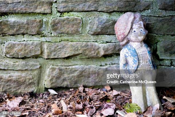 vintage wooden garden gnome against stone wall - 庭の置��物 ストックフォトと画像