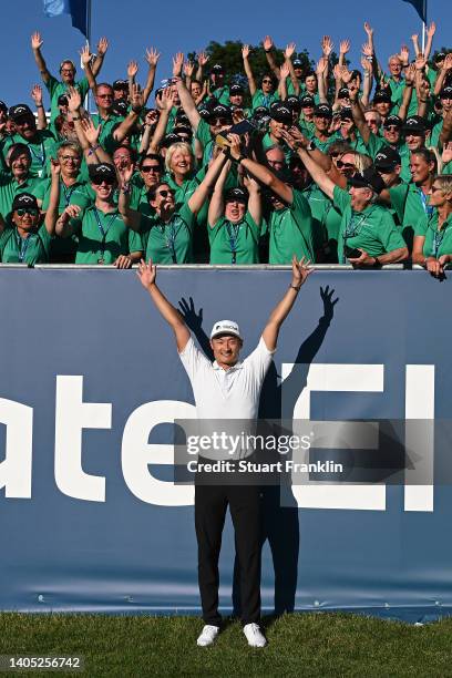 Haotong Li of China poses with the winner's trophy alongside event volunteers following Day Four of the BMW International Open at Golfclub Munchen...