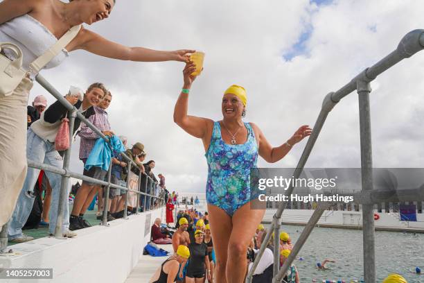 Swimmer accepts a drink after taking part in a successful Guinness World Record attempt for the largest number of people performing a synchronised...