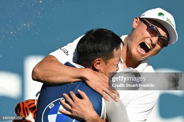 Haotong Li of China celebrates with their caddie on the 18th hole following the playoff during Day Four of the BMW International Open at Golfclub...