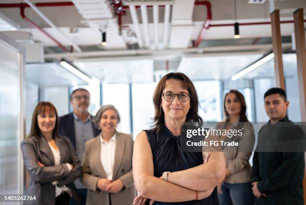 portrait of businesswoman and team in the office - chief financial officers stock pictures, royalty-free photos & images