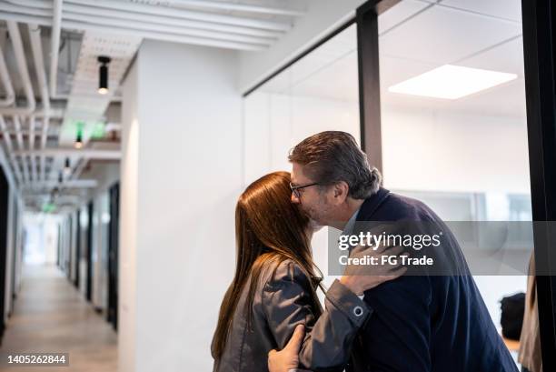 senior businessman greeting employee in the office - kussen stockfoto's en -beelden