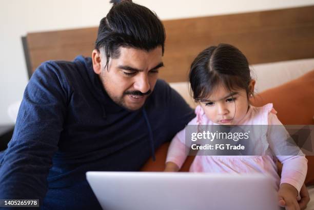 father and daughter using the laptop at home - no 2012 chilean film stockfoto's en -beelden