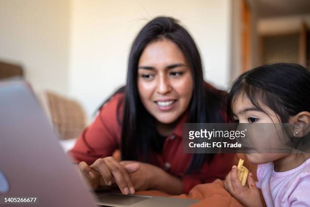 mother and daughter using laptop together at home - no 2012 chilean film stockfoto's en -beelden