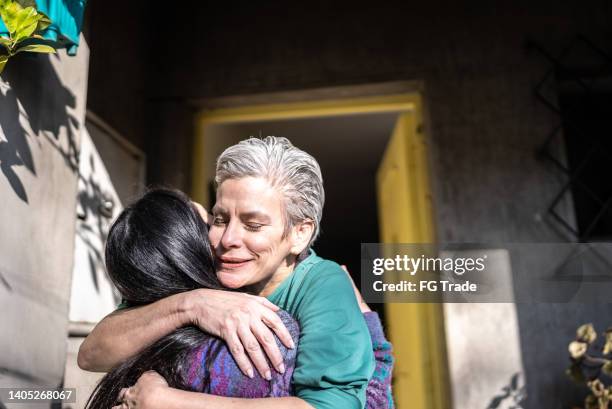 mother welcoming daughter at home - candid moments stock pictures, royalty-free photos & images