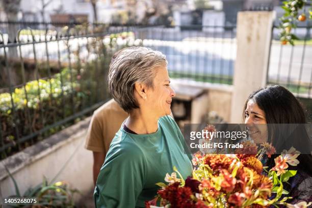 madre che riceve un mazzo di fiori dalla figlia a casa - i love you mum foto e immagini stock