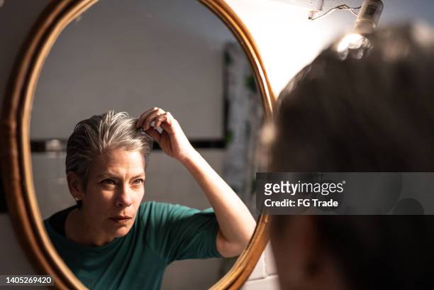 reife frau, die sich zu hause fertig macht - gray hair stock-fotos und bilder