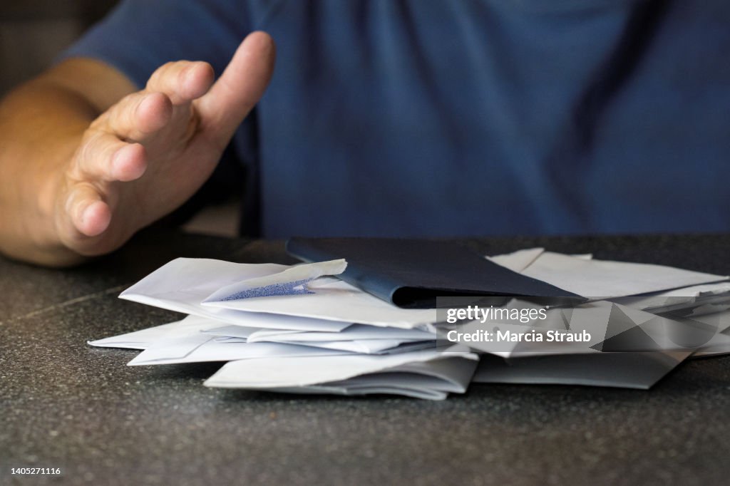 Hands of a Woman with Envelopes and Check Book Paying Bills