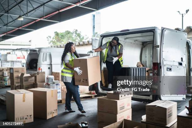 trabajadores de almacén cargando furgoneta con cajas - transito fotografías e imágenes de stock