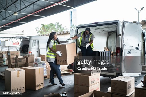 Warehouse workers loading van with boxes Warehouse workers loading van with boxes