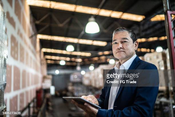 portrait of a warehouse worker using digital tablet - old warehouse stock pictures, royalty-free photos & images
