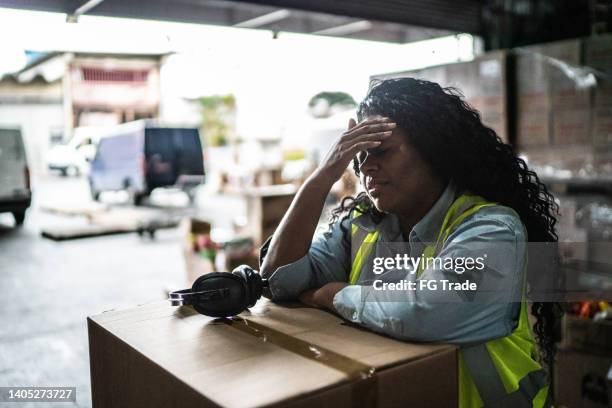 tired or worried female warehouse worker - compression imagens e fotografias de stock