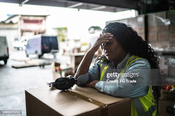 tired or worried female warehouse worker - tensão imagens e fotografias de stock