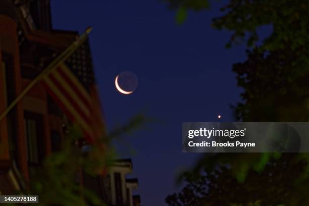 the rising moon and venus in conjunction and captured at nautical twilight in boston's historic south end. - venus symbol stock-fotos und bilder