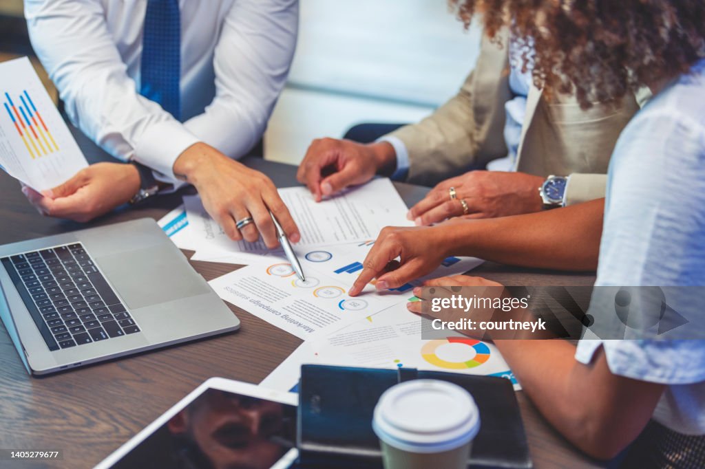 Close up of people pointing to a graph with data.