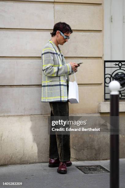 Guest wears pale blue sunglasses, silver earrings, gray with neon yellow and blue checkered print pattern blazer jacket, dark brown suede large...